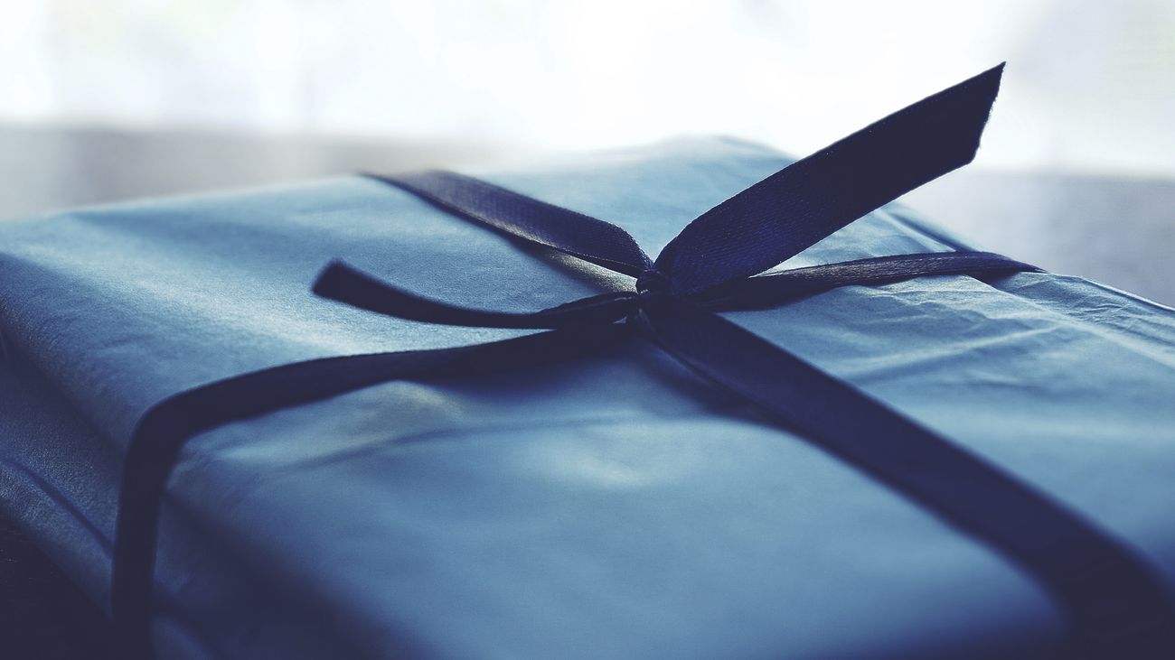 a wrapped gift in plain blue paper and dark blue ribbon